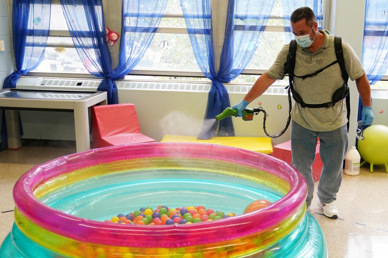 A worker sanitizes school equipment in a classroom in Brooklyn, New York City, New York, on September 2, 2020. 