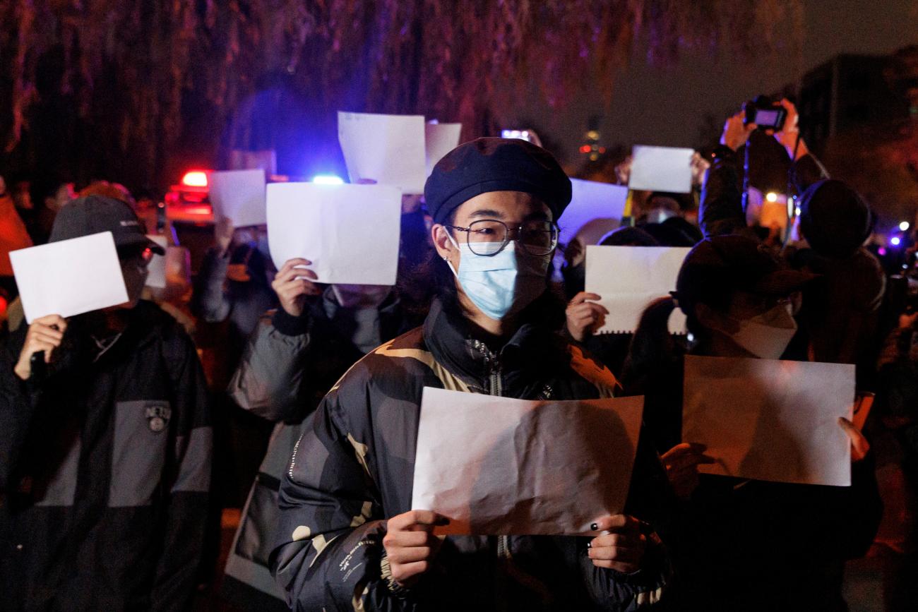 People gather for a vigil in protest over COVID-19 restrictions, during a commemoration of the victims of a fire in Urumqi, in Beijing, China, November 27, 2022.