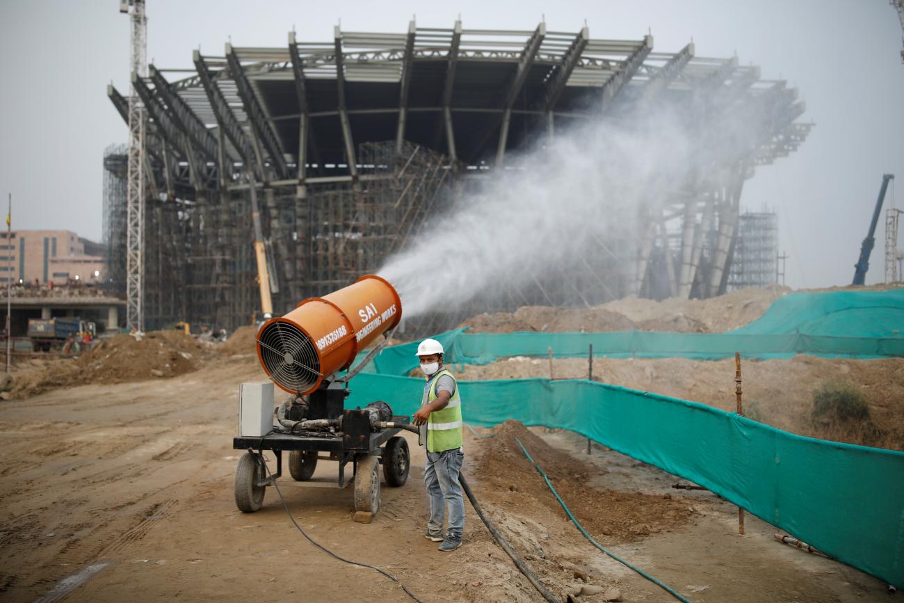 A worker operates an anti-smog gun, a water cannon used to disperse the suspended dust particles that are settled in the air to form thick smog, at a construction site in New Delhi, India, on October 14, 2020.