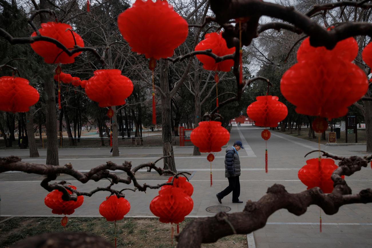 A man walks past a tree decorated with Spring Festival ornaments in a park ahead of Chinese Lunar New Year festivities in Beijing, China January 11, 2023. REUTERS/Thomas Peter