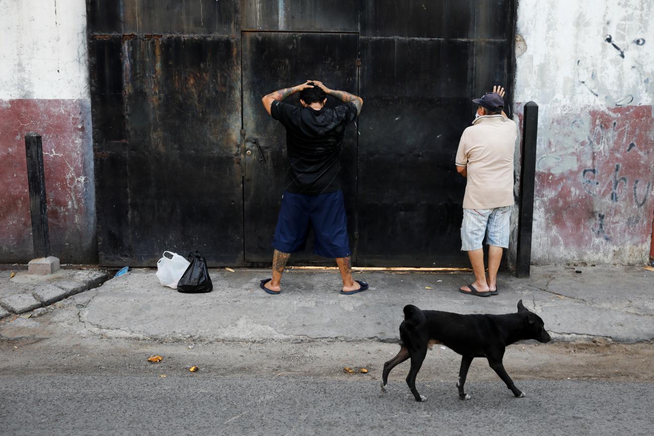 Men are detained during a military operation, part of security measures ordered by El Salvador's President Nayib Bukele to keep people in their homes during a countrywide COVID quarantine, in La Libertad, El Salvador, April 18, 2020.