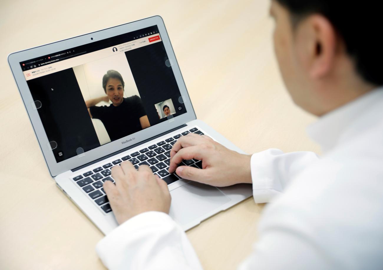 Medical doctor Makoto Kitada demonstrates a telemedicine application service called 'CLINICS', developed by Japanese medical start-up Medley Inc., in Tokyo, Japan, July 8, 2020.