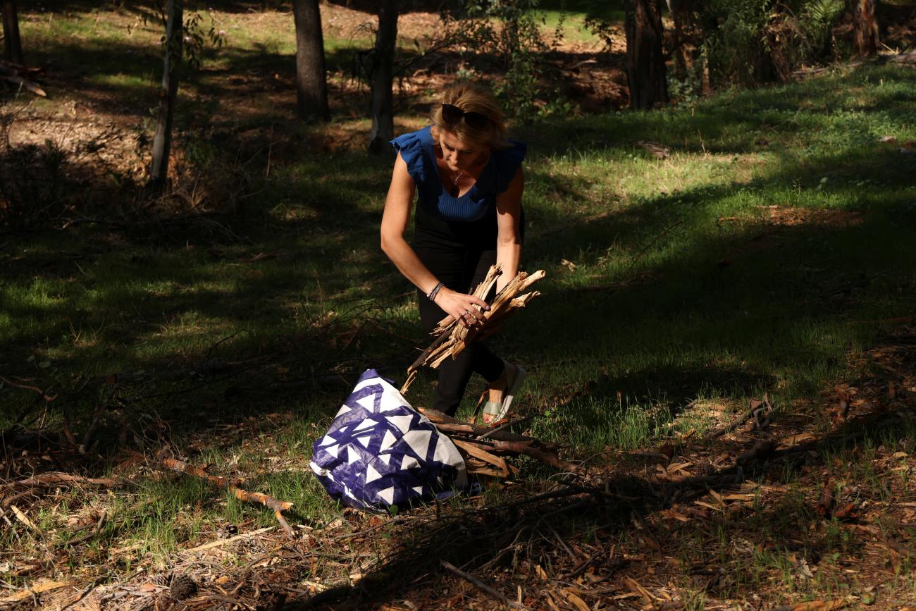 A woman collects logs at a municipal park as local officials provide free firewood for the upcoming winter months, in Athens, Greece, September 12, 2022. REUTERS/Stelios Misinas