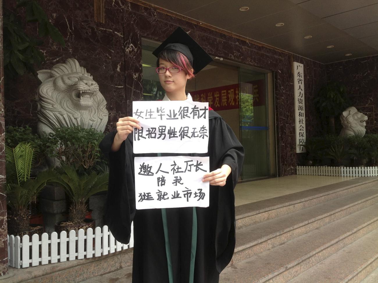 Women activist Zheng Churan, twenty-five, poses for a photograph with papers that read "Women graduates are talented, only hiring men is frustrating" (top) and "I invite the head of Human Resources and Social Security department to go to the job market with me", in this undated handout picture taken in an unknown location in China, provided by a women's rights group on April 8, 2015.  The women were taken into custody on the weekend of International Women's Day, March 8, and later detained.