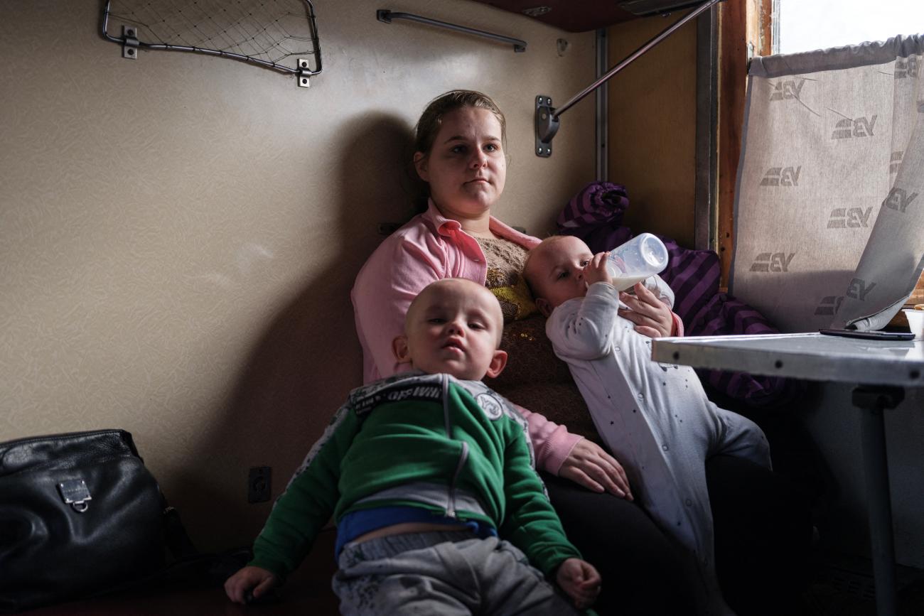 Iryna Hryhorieva sits with her children, Bohdan and Karolina, inside an evacuation train at the train station in Pokrovsk, Donetsk region, Ukraine, after leaving their village of Min'kivka.