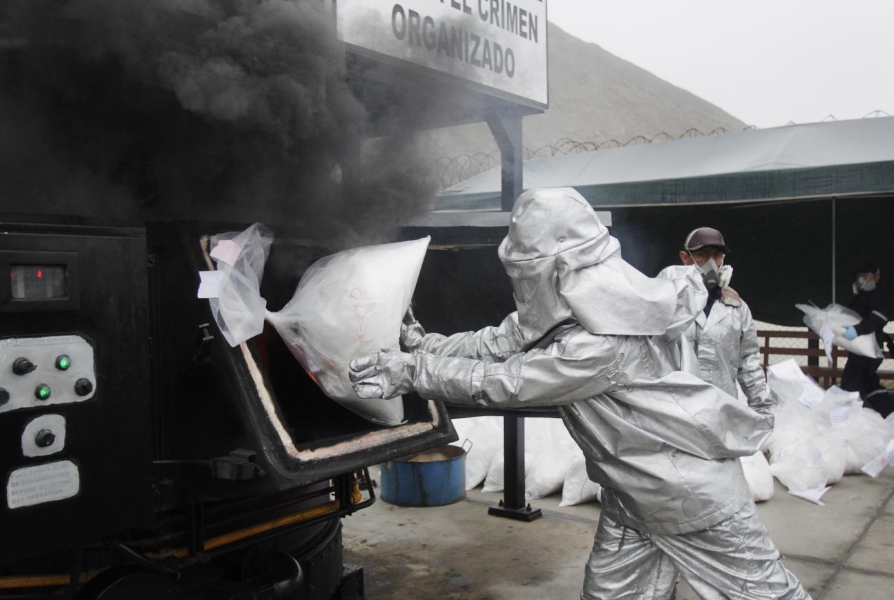 Anti-narcotics officers burn bags of the cocaine seized last week near Trujillo at a special operation police headquarters in Lima, on September 3, 2014.