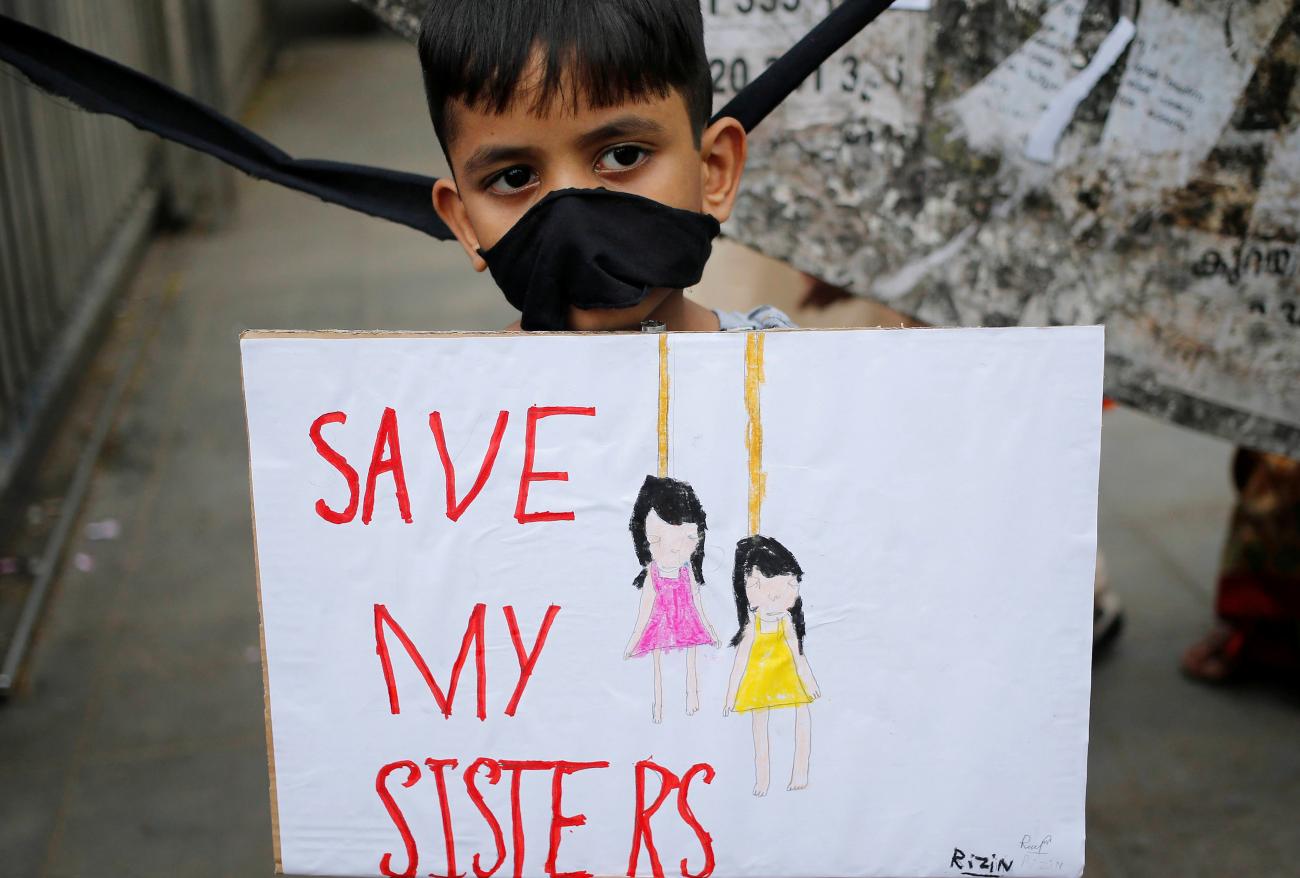 A boy along with demonstrators holds a placard during a protest demanding justice for two sisters who according to local media were sexually assaulted and murdered by three men in 2017 in the southern state of Kerala, in Kochi, India, on October 29, 2019.