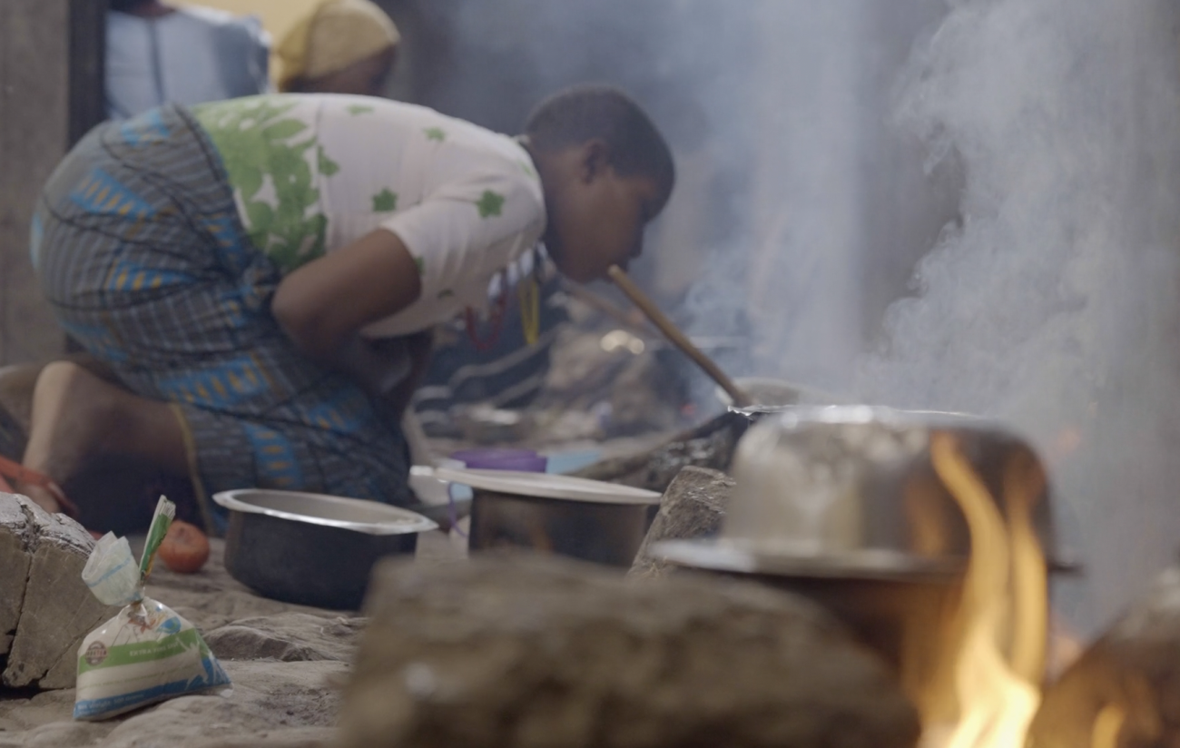 A young woman in Itigi, Tanzania cooking for her family over an open fire at St. Gaspar Hospital. Photo credit