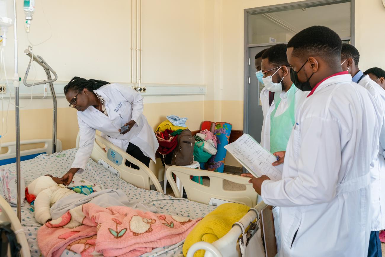 Dr. Rose Alenyo does patient rounds in the burn ward while her trainees learn from her compassionate bedside manner, at Kiruddu Hospital, in Kampala, Uganda.   