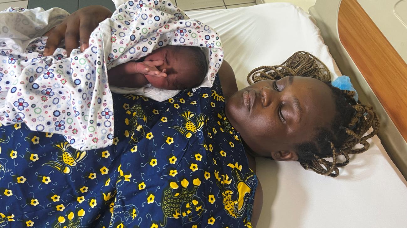 Karen, twenty-seven, and one of her twins, Karen Njong, lie on a bed at the National Hospital Abuja, in Abuja, Nigeria, on November 15, 2022. 