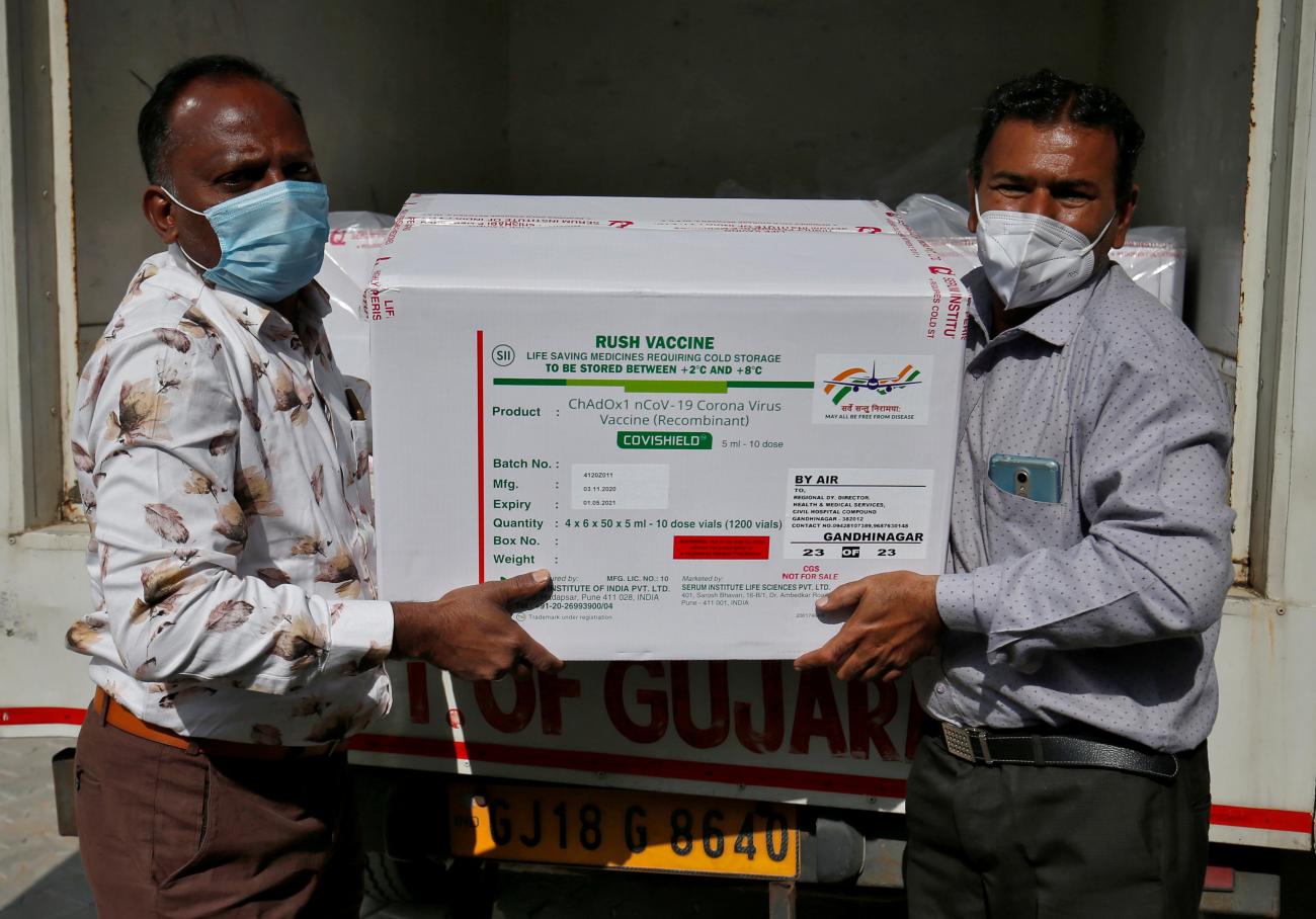 Officials unload boxes containing vials of COVISHIELD, a coronavirus disease (COVID-19) vaccine manufactured by Serum Institute of India, after a consignment of the vaccines arrived from the western city of Pune for its distribution, outside a vaccination storage center in Ahmedabad, India, on January 12, 2021.
