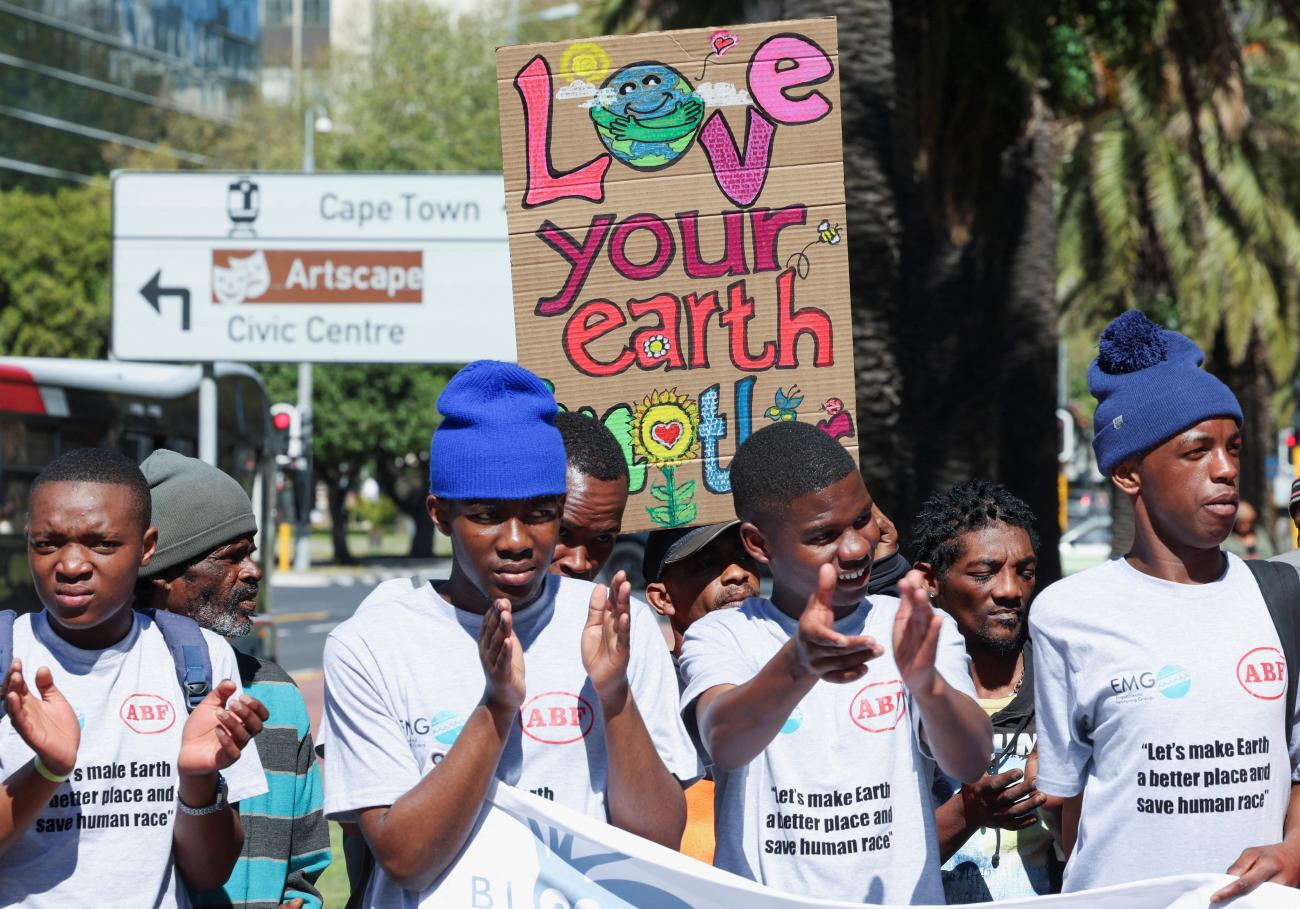 An activist holds a sign as they call for climate justice and an end to fossil fuels during the Southern Africa Oil and Gas Conference in Cape Town, South Africa, September 13, 2023.