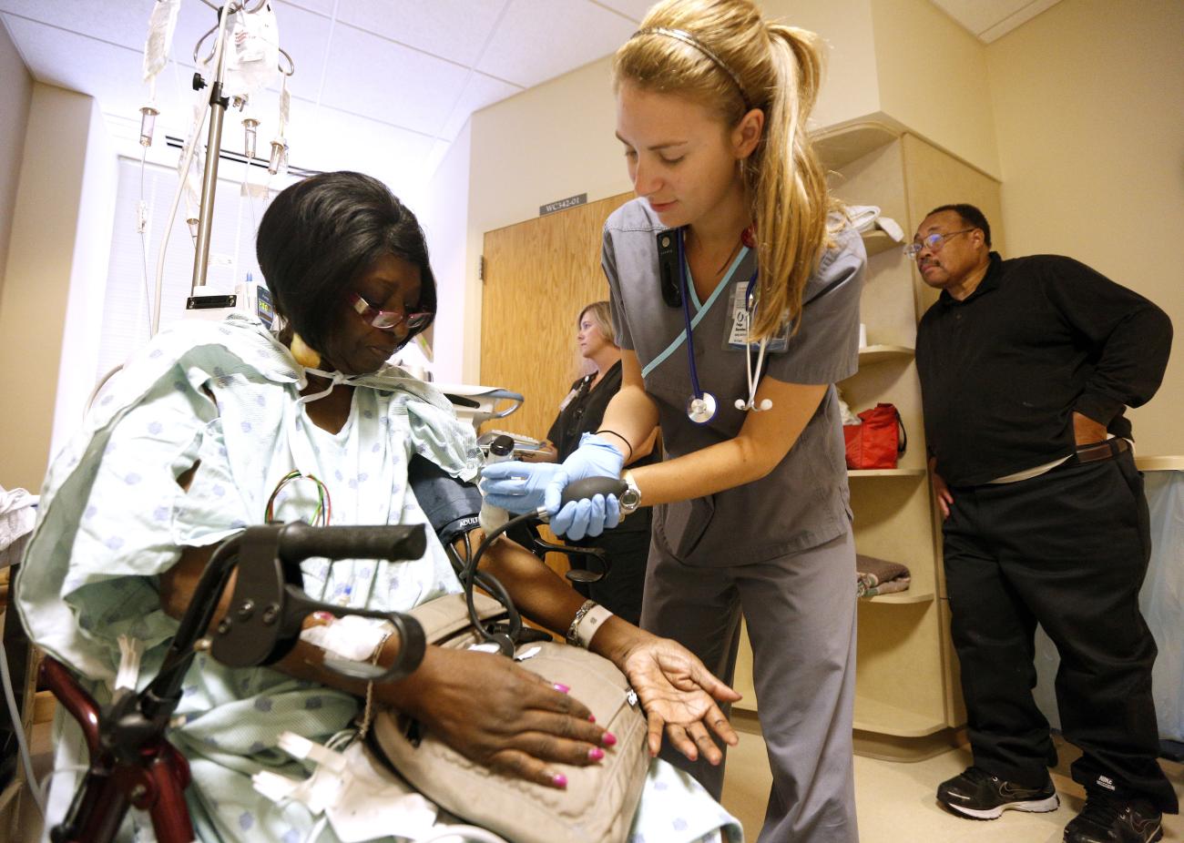 ARegistered nurse Paige Duracher checks Jacqueline Parker's vitals.