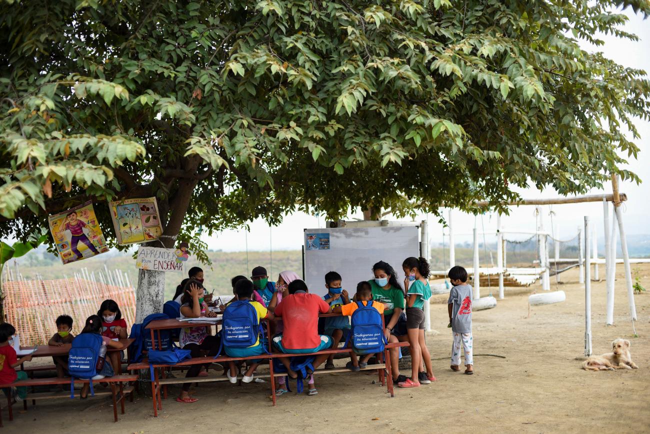 A 16-year-old student, teaches children in an improvised school she has set up under a tree.