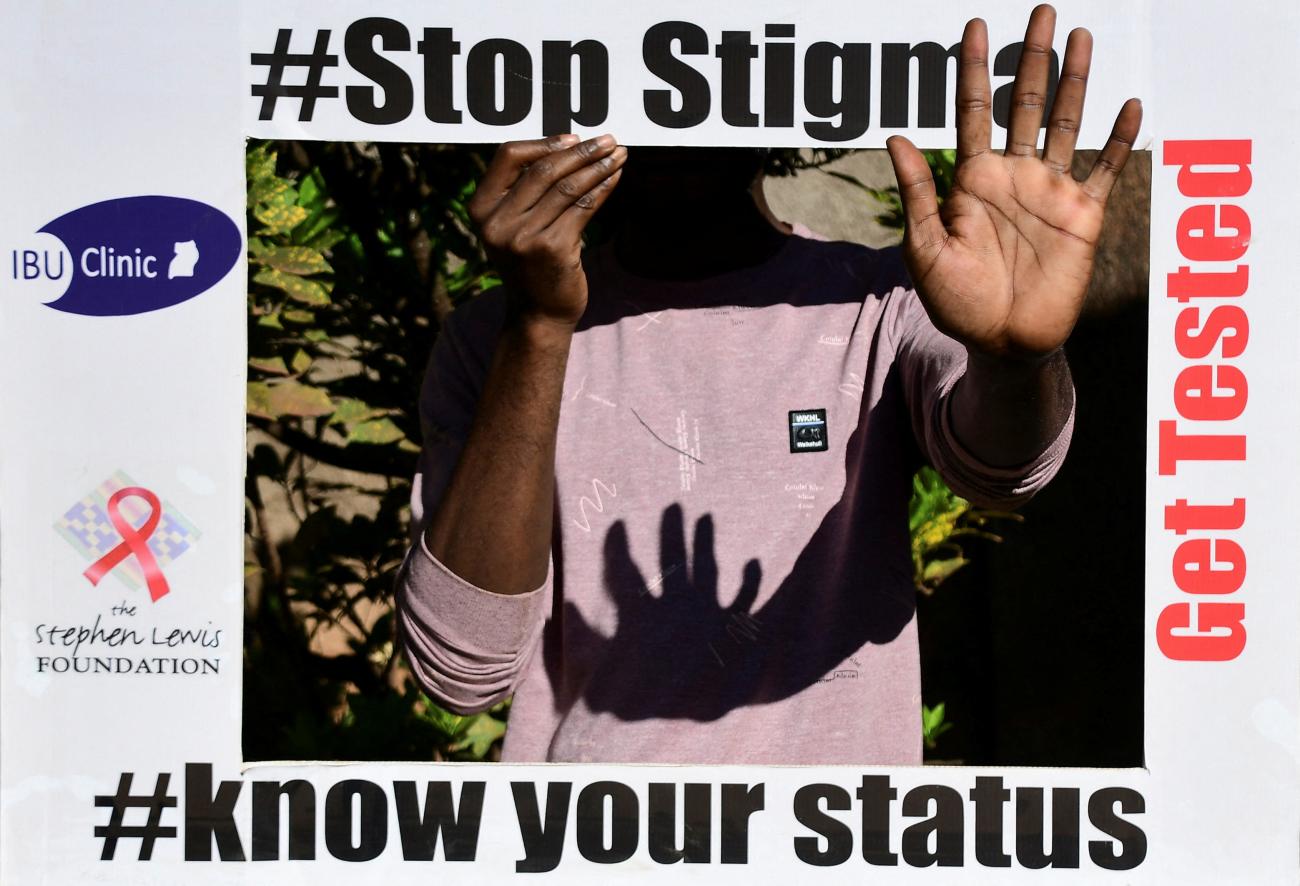 An unidentified member of the LGBTQ community holds an advocacy placard as he poses for a photograph at the Ice Breakers Uganda (IBU) clinic in Makindye that supports HIV/AIDS programs.