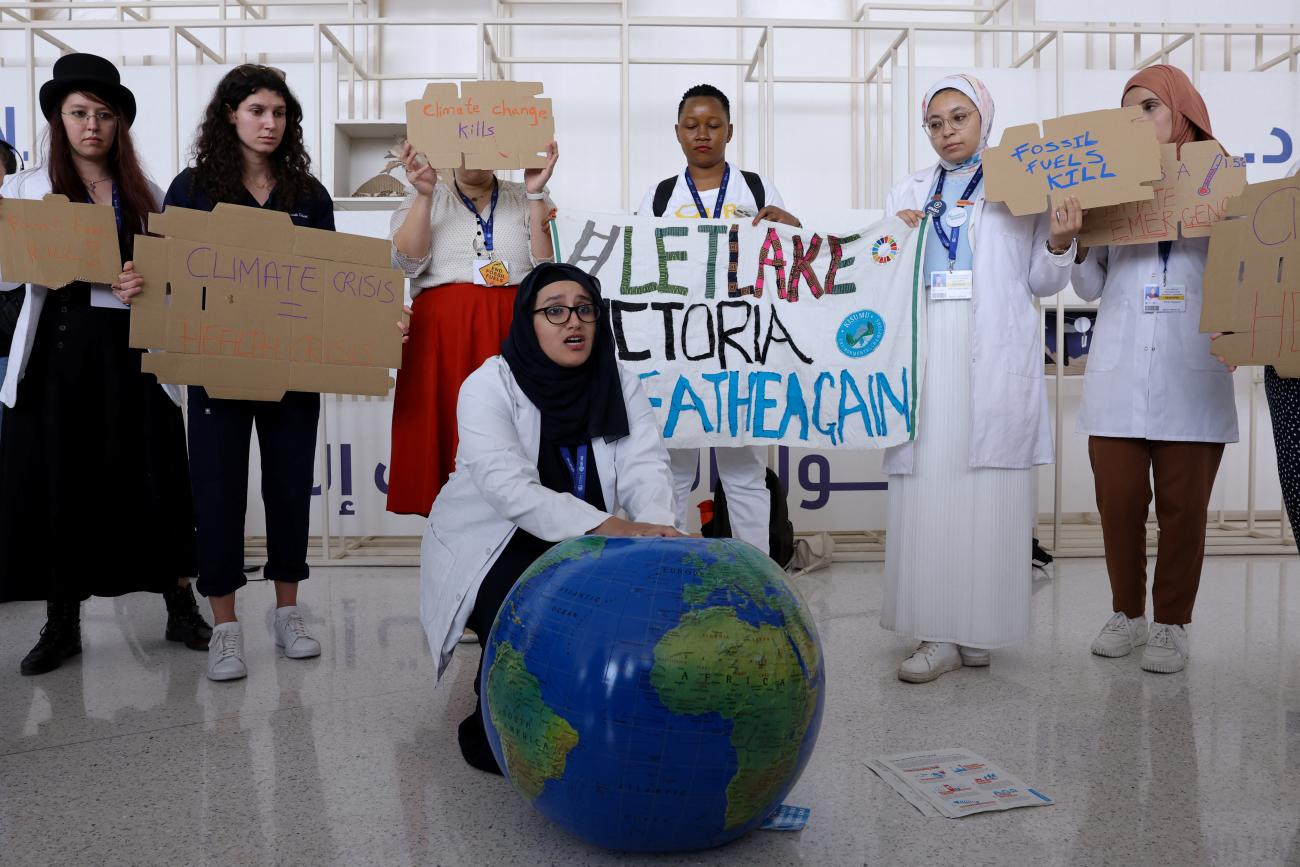Members of the International Federation of Medical Students Associations hold placards during a protest,
