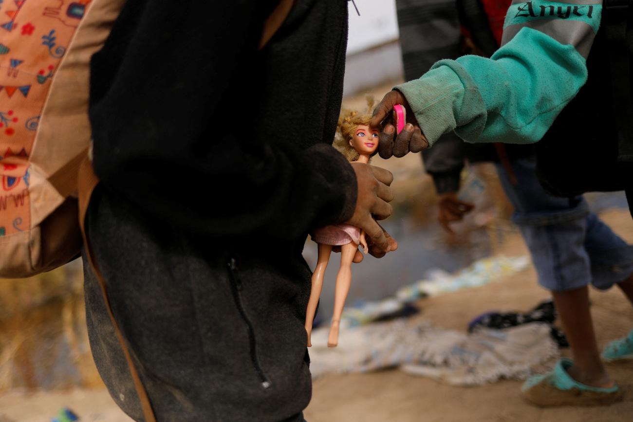 Juliana, a Haitian migrant girl travelling with her family, carries a doll before crossing the Rio Bravo river, the border between the United States and Mexico, with the intention of turning themselves in to the U.S. Border Patrol agents to request asylum, in Ciudad Juarez, Mexico January 2, 2024.