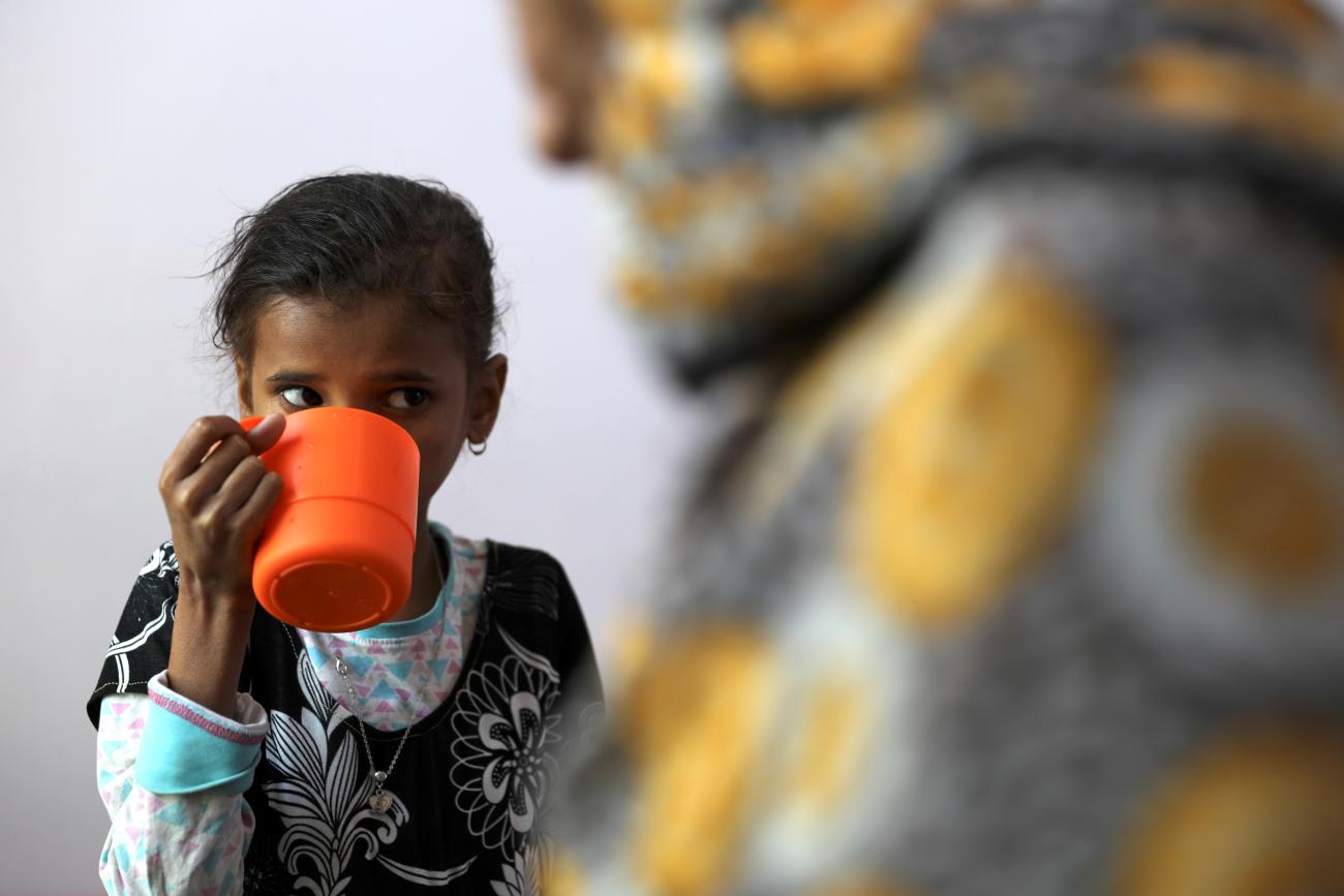 A young girl drinks a supplemental nutrition shake at malnutrition treatment ward.