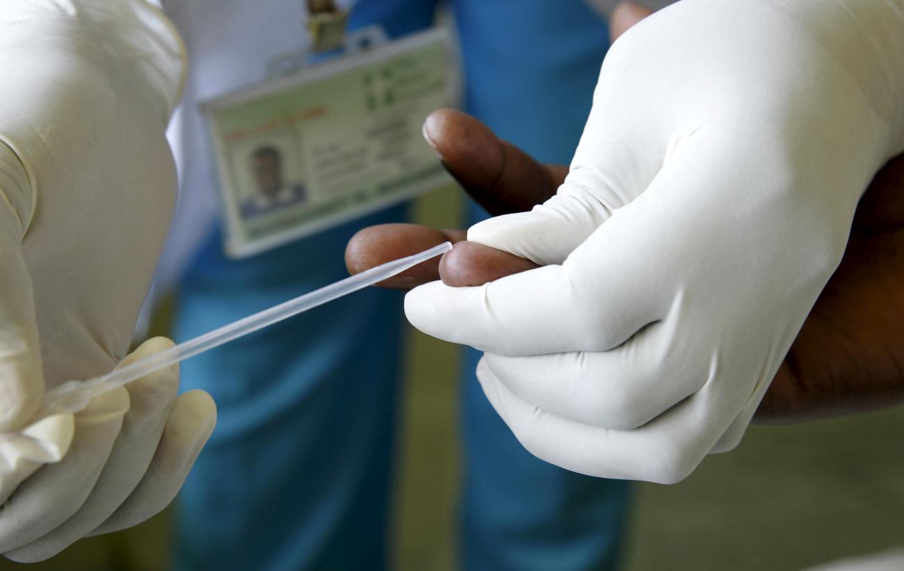 A Counsellor prepares to get a blood sample from a woman to test for HIV.