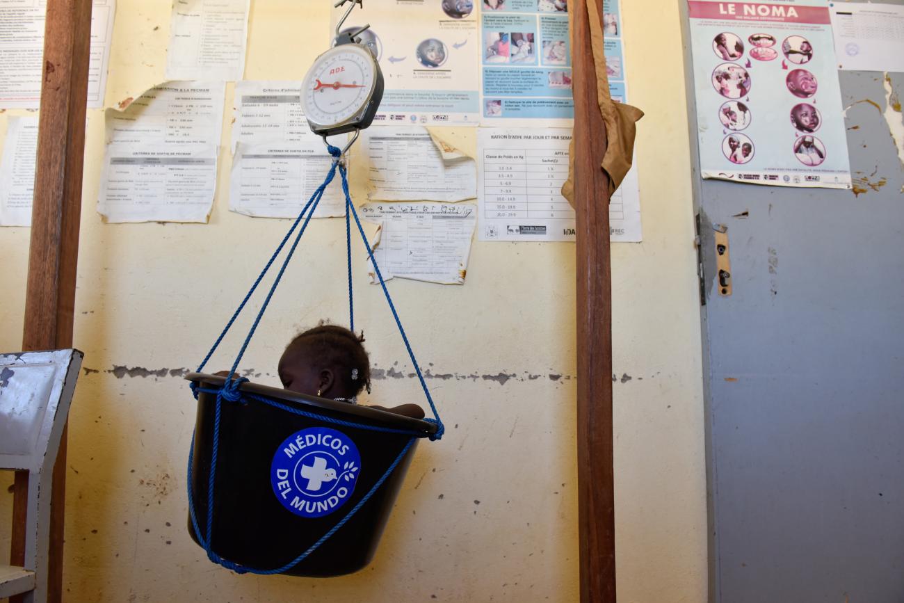 Fatimata Badini, 13 months old, sits in a weighting scale bowl during a free medical consultation, as part of the malnutrition fighting plan at the Medical Center's maternity ward in Dori, Burkina Faso, November 24, 2021.