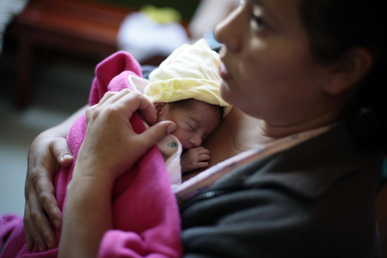 A mother hugs her baby.