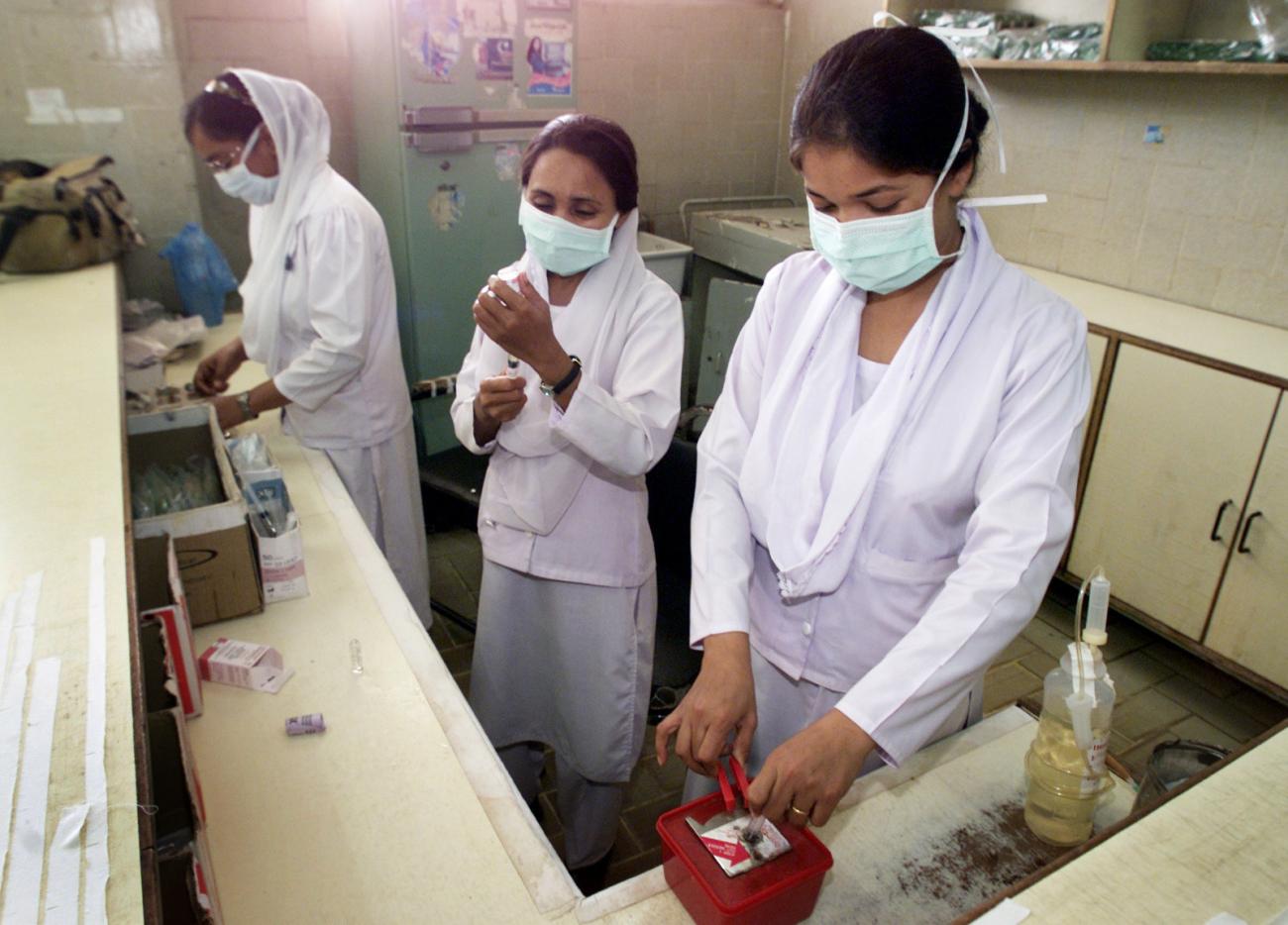 Pakistani nurses wear masks to protect themselves against SARS.