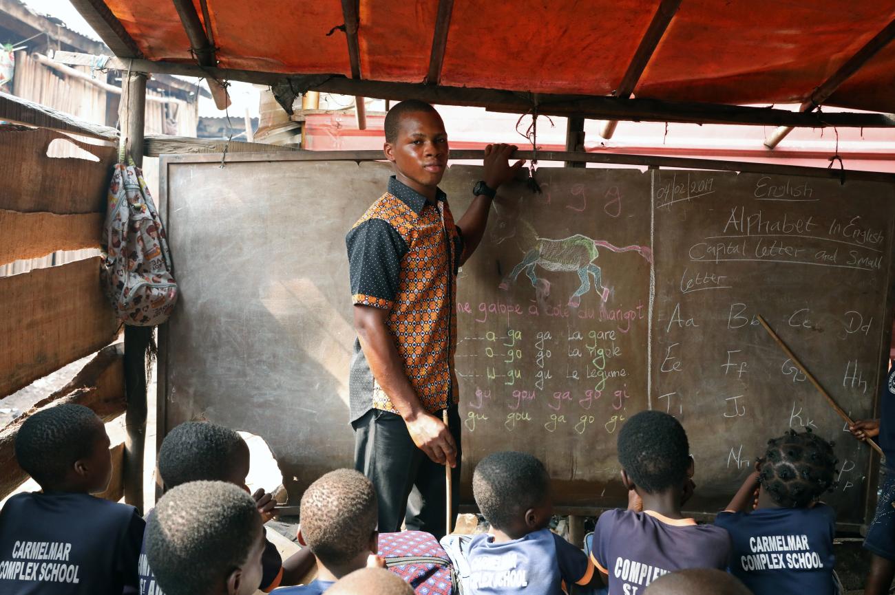 Azonmayon Moses, 21-year-old teacher, poses for a picture in his classroom in the Makoko shanty town in Lagos, Nigeria.