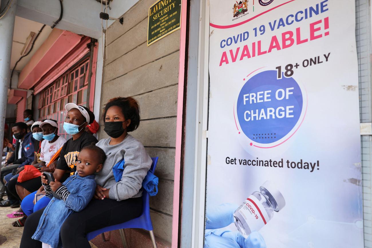 People wait in line to receive the COVID-19 vaccine, at the Penda health center.