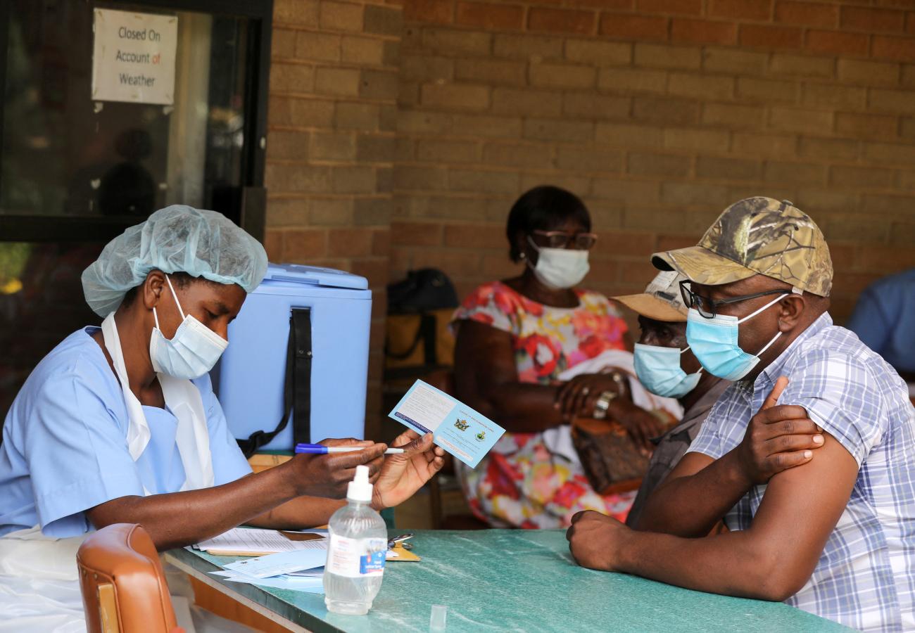 A man receives a certificate after being vaccinated against COVID-19 at Wilkins Hospital.