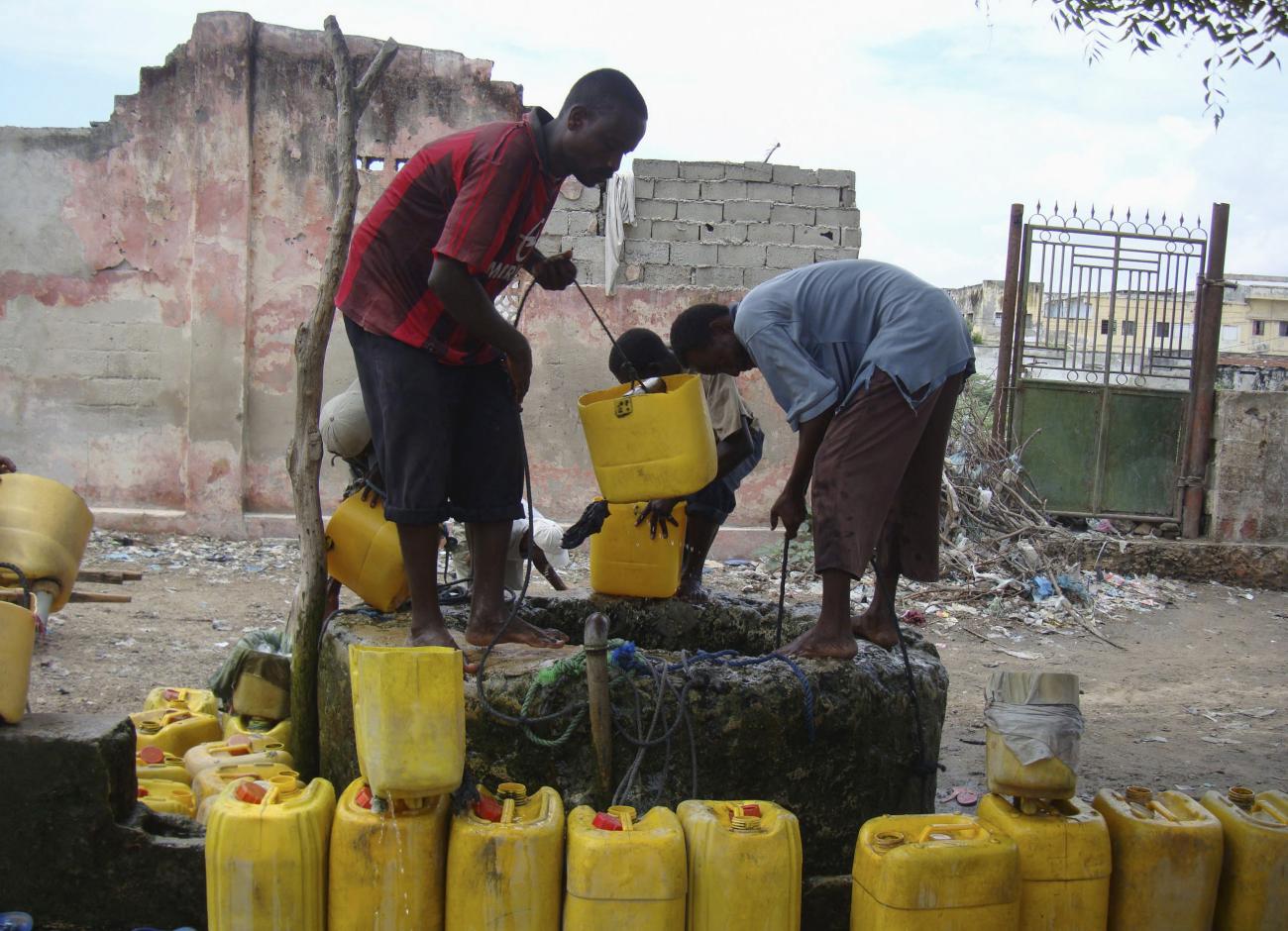 Residents draw water from a well following water shortages.