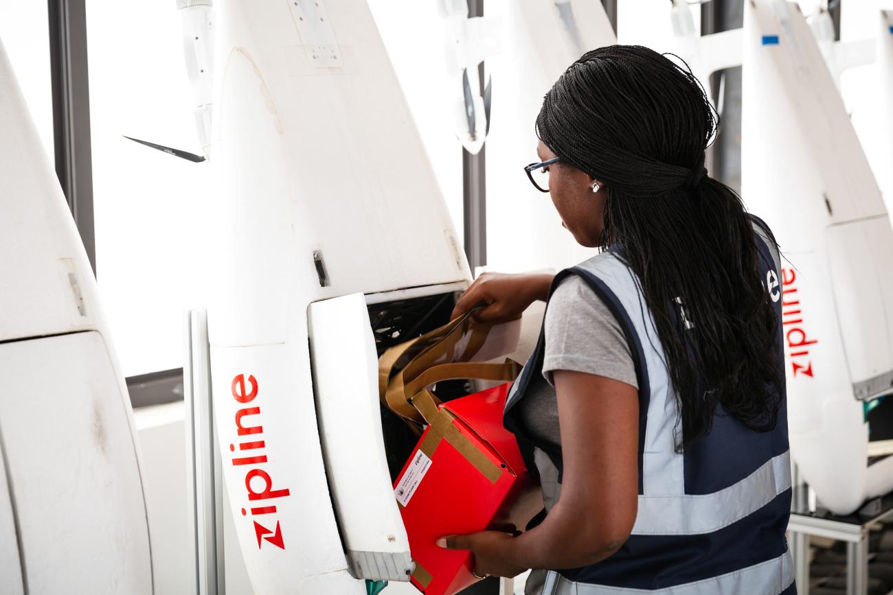 A woman packs a box of vaccines to be delivered by a Zipline drone.