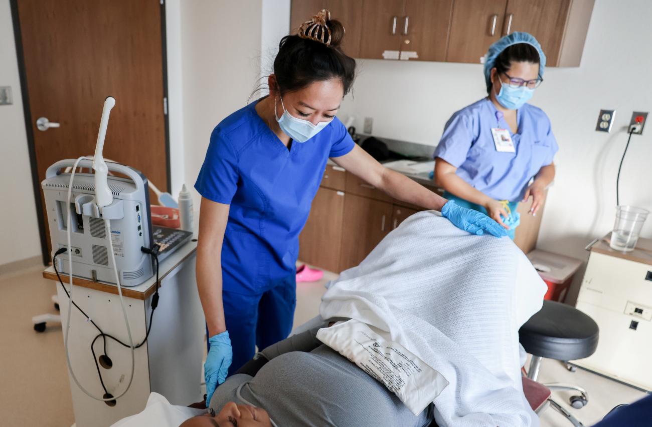 Shelly Tien, MD, is seen with a patient at Trust Women clinic.