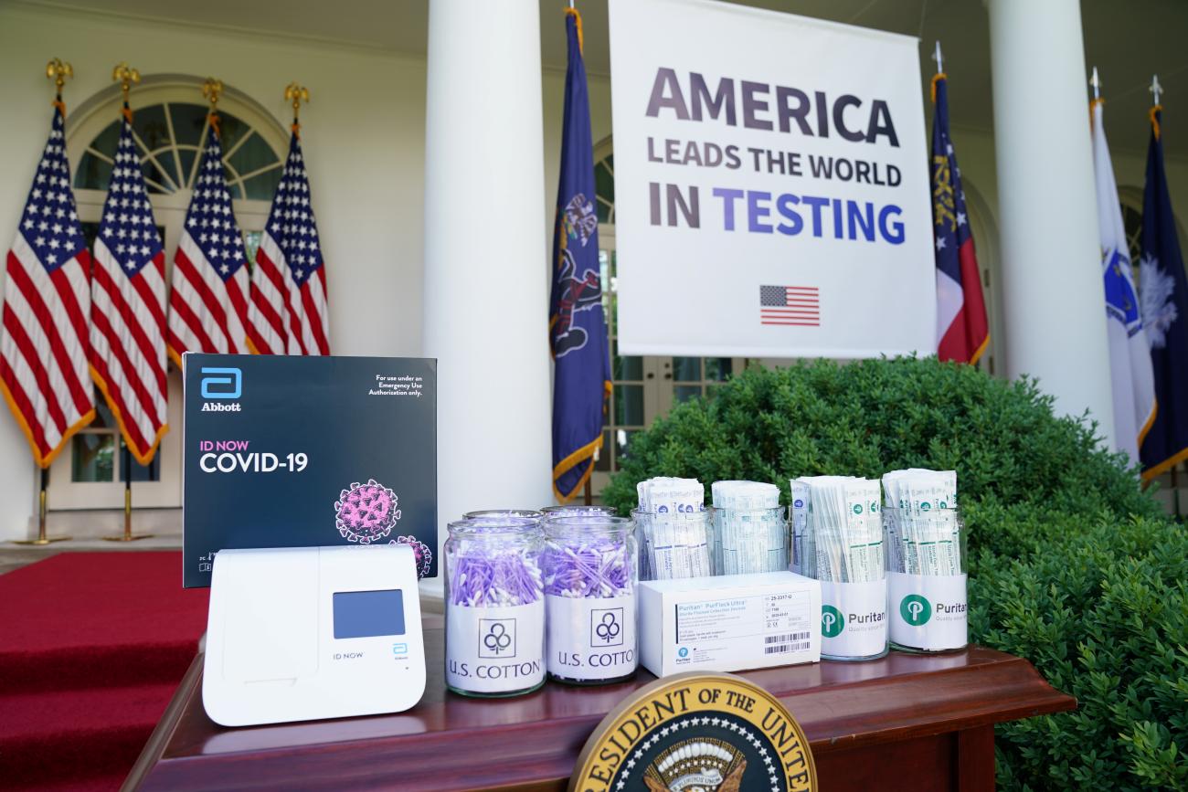 A COVID-19 testing machine and the swabs used to administer tests sit on a table in the Rose Garden at the White House.