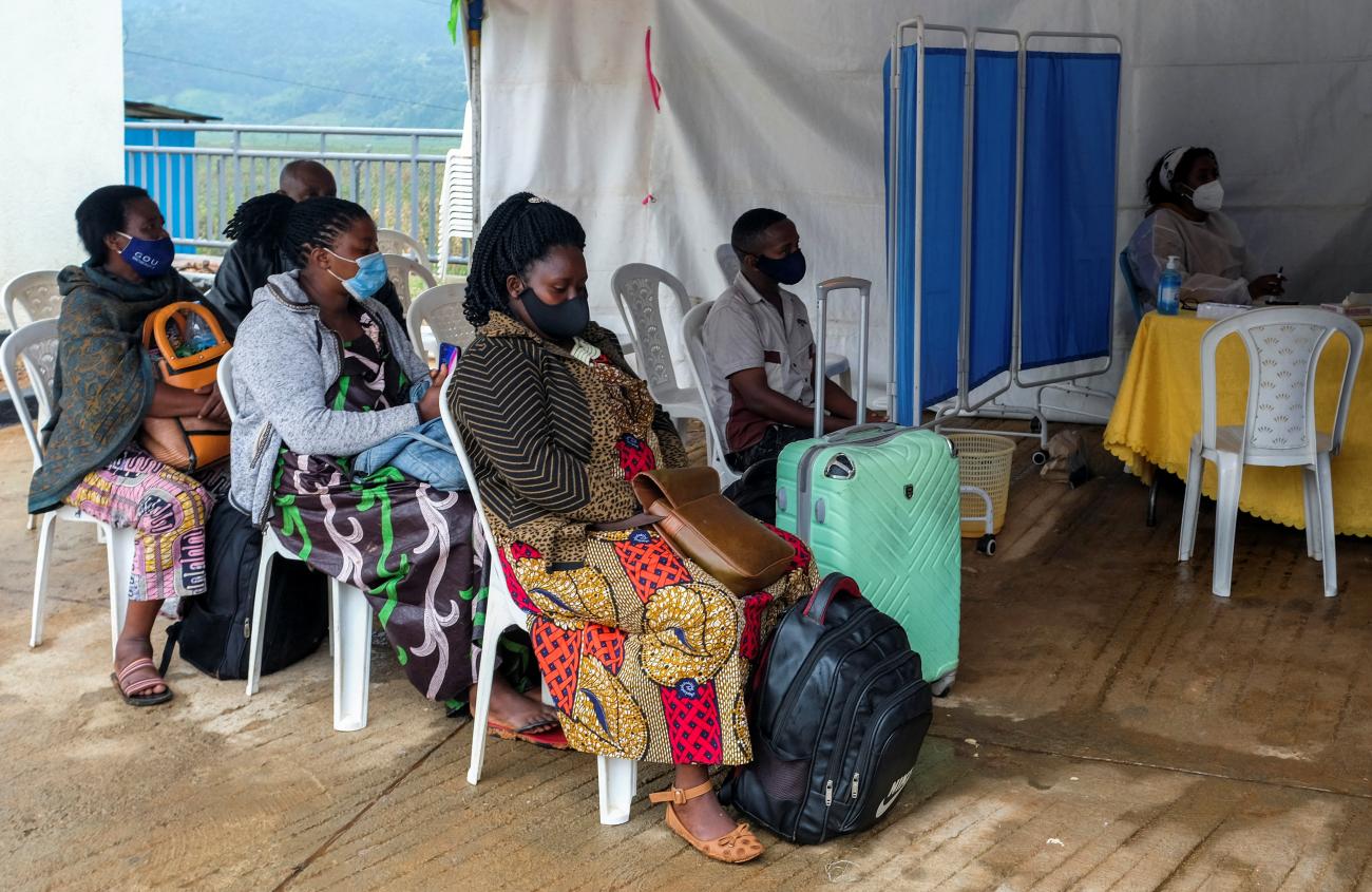 Travelers sit at the health port as they wait for a COVID-19 test at the Gatuna one-stop border post at Gicumbi.