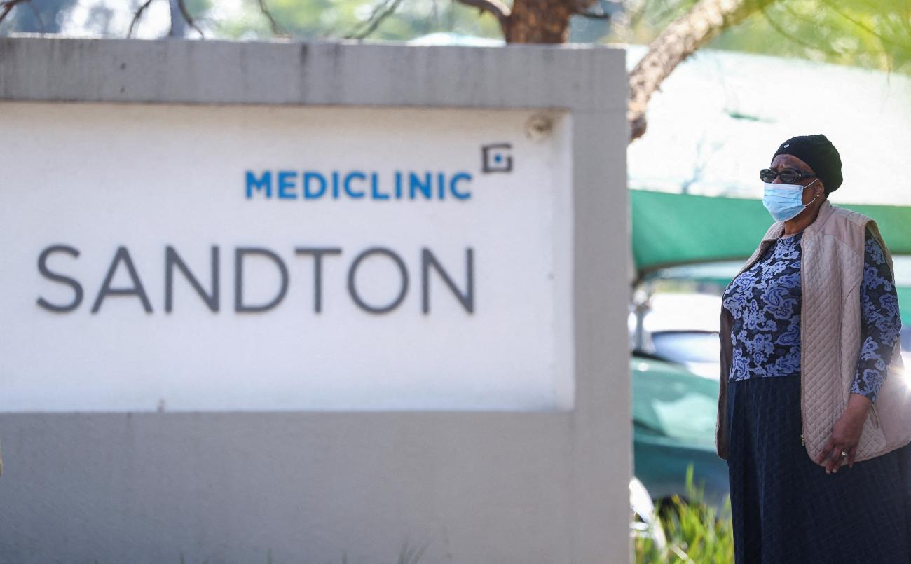 A woman stands at the entrance of Mediclinic.