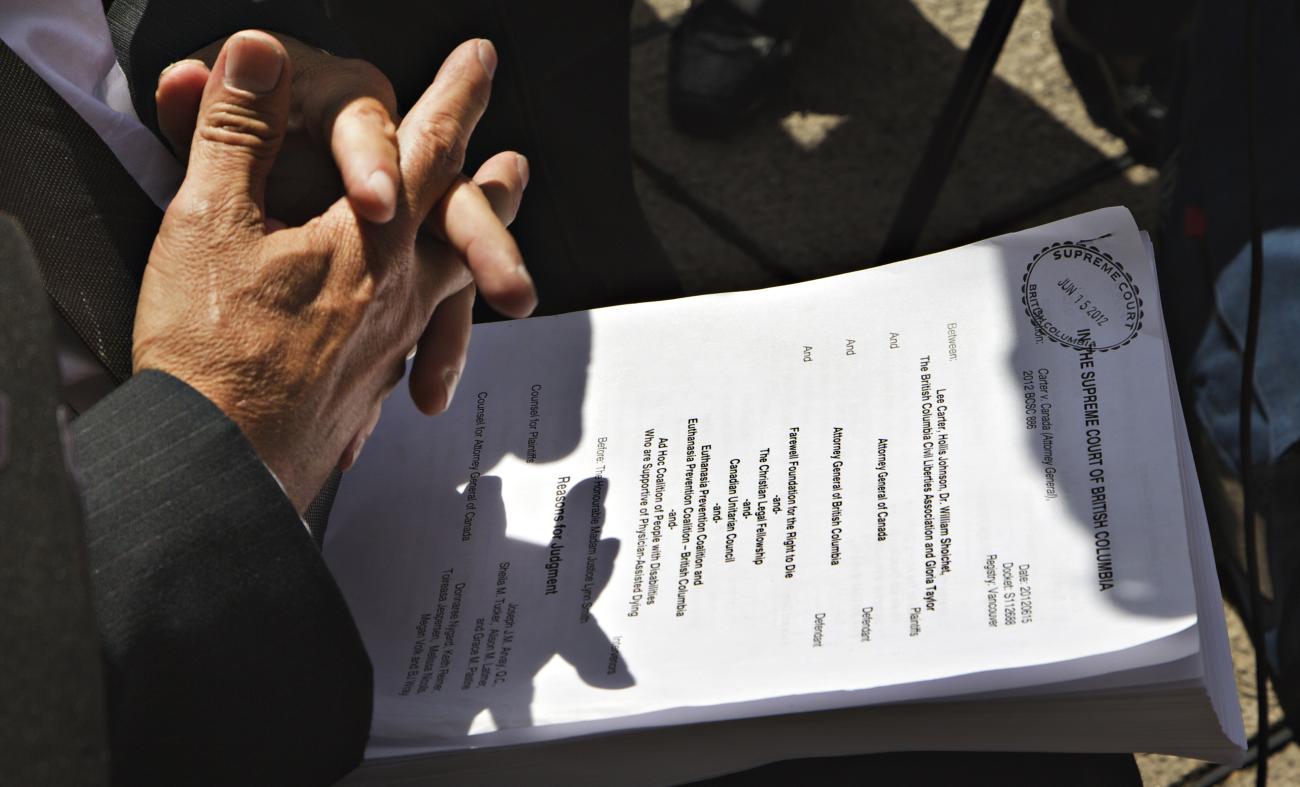 Lawyer Joseph Arvay sits with a copy of a ruling on doctor-assisted suicide outside the British Columbia Supreme Court in Vancouver, British Columbia June 15, 2012.