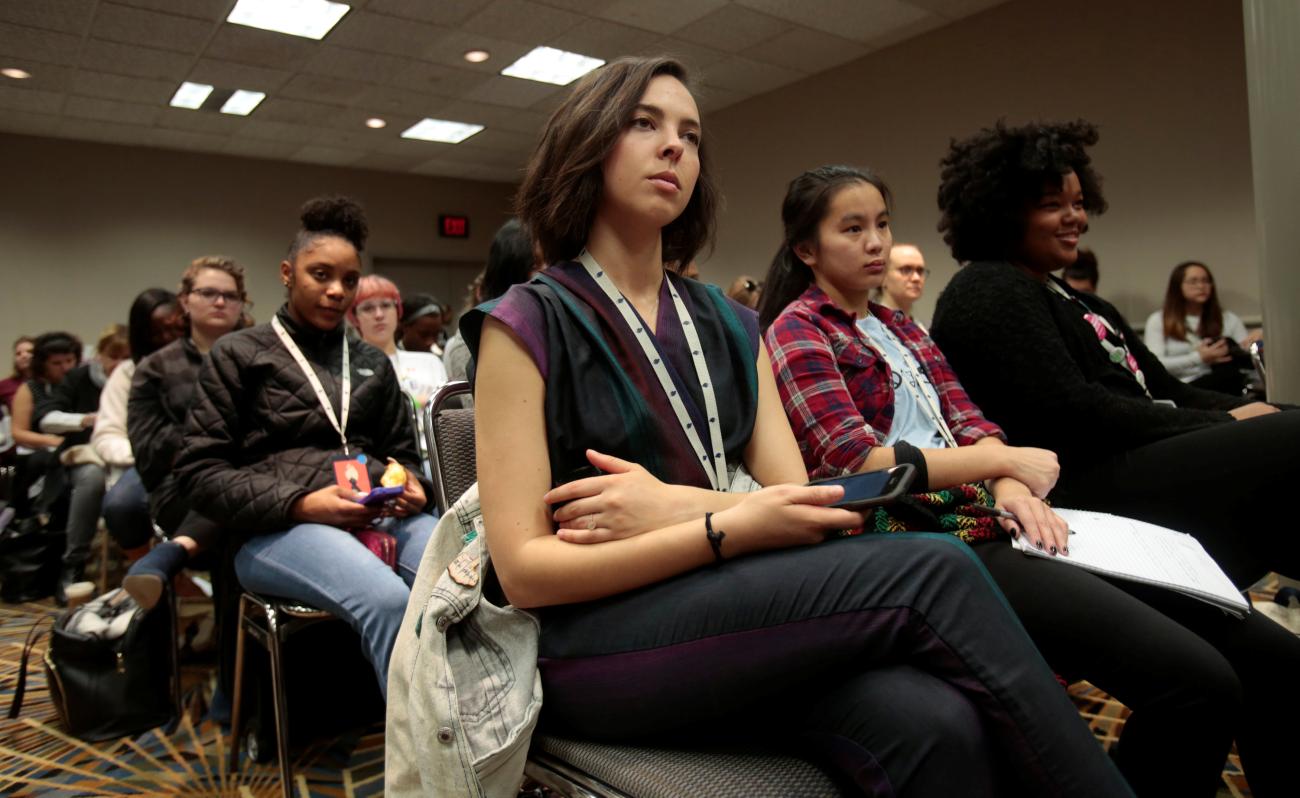Attendees listen to a presenter during a 'Social Media Training for Youth' panel discussion.