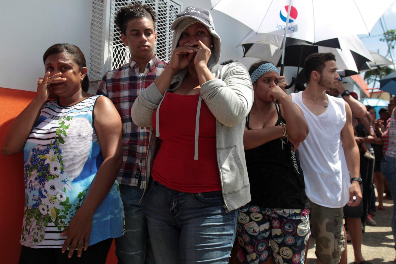 People wait in line for aid items to be handed out, after the area was hit by Hurricane Maria.