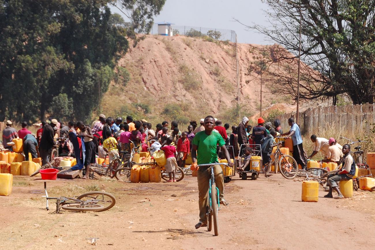 People fetch water outside a copper and cobalt mine, in Kolwezi, Democratic Republic of Congo, on May 30, 2015. 