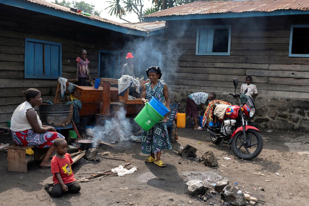 A woman cooks for her kids as they take refuge while violence continues between M23 rebels and the FARDC, in Goma, Democratic Republic of Congo, on February 2, 2025.