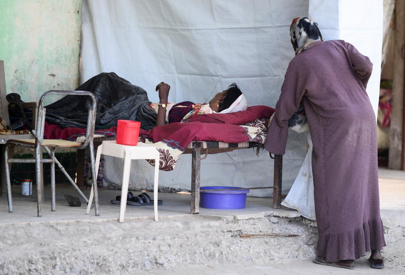 A displaced Sudanese woman rests on a bed at "Abdallah Nagi" shelter camp, in Port Sudan, Sudan, on April 15, 2025. 