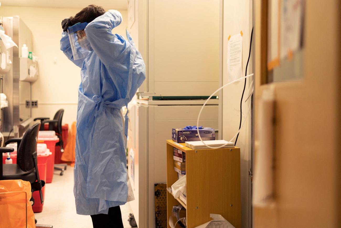A graduate student puts on his personal protective equipment at the University of Pennsylvania's Perelman School of Medicine, in Philadelphia, Pennsylvania, on December 16, 2021.