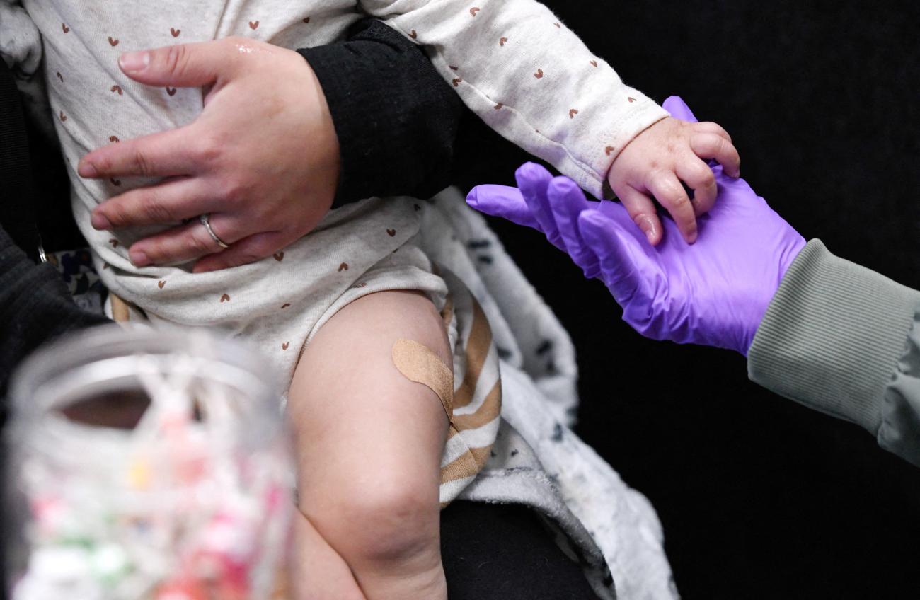 A parent holds their child after the administration of the first MMR vaccine dose, at the City of Lubbock Health Department, in Lubbock, Texas, on February 27, 2025.