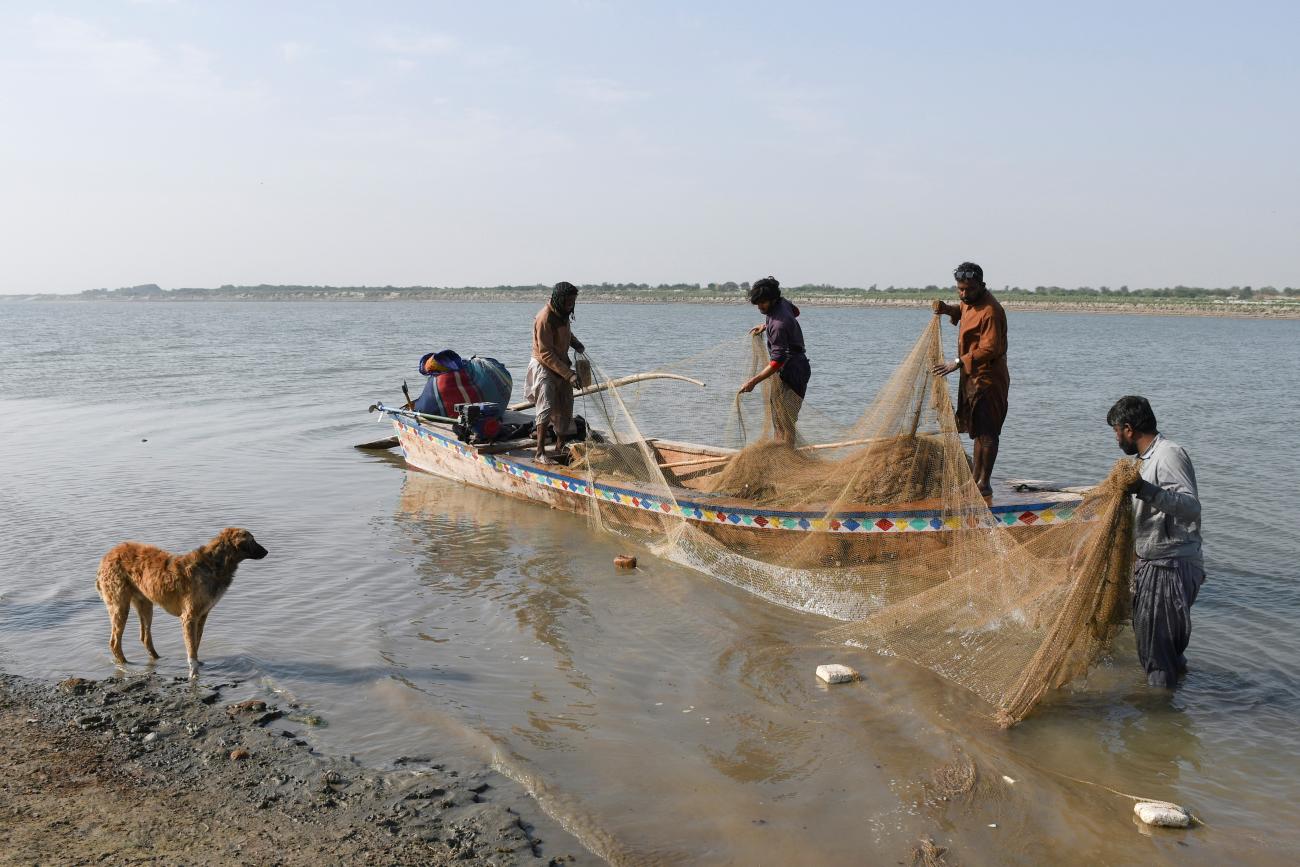 Fishermen clear their net after a catch on the Indus River, in Hyderabad, Pakistan, on March 15, 2025.