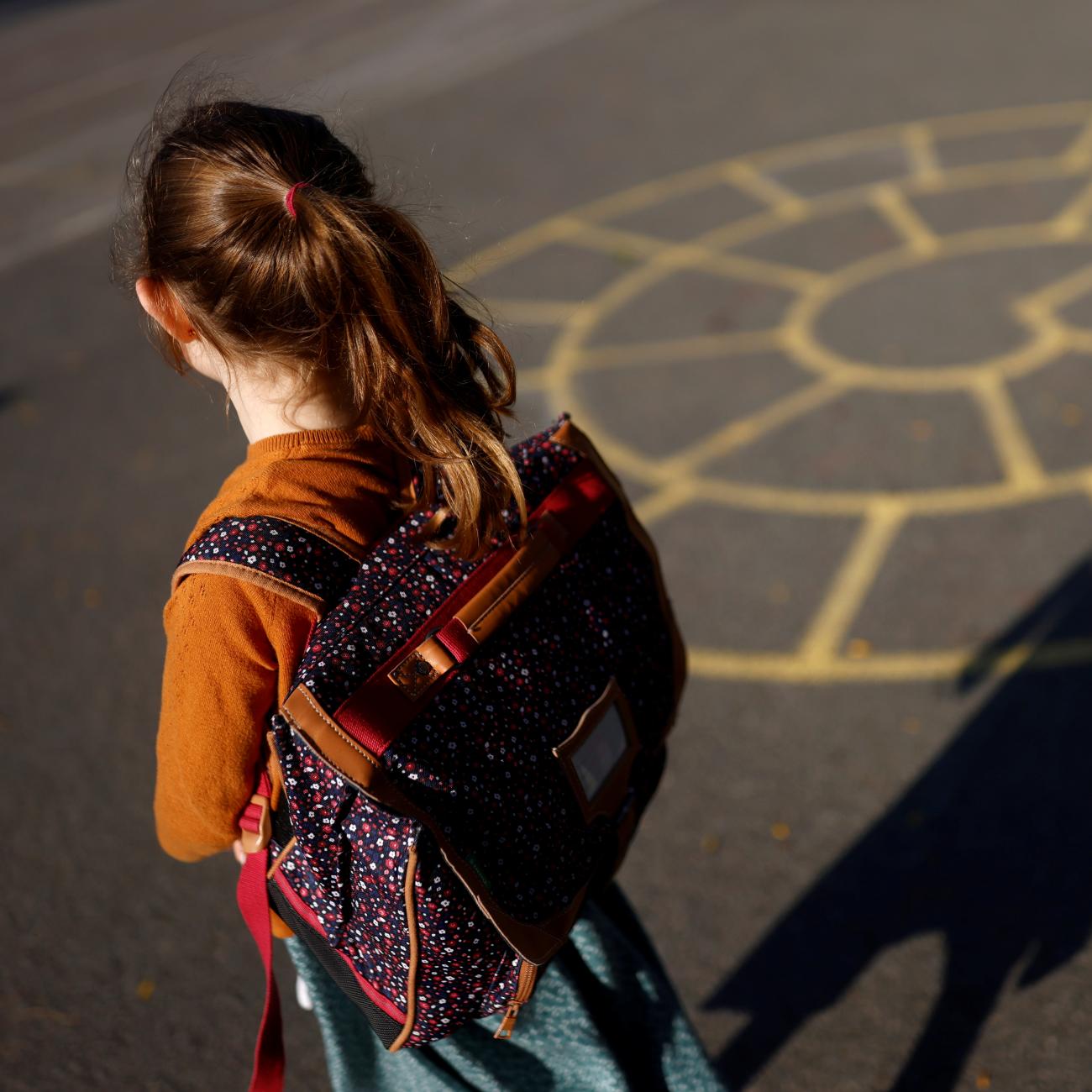 A child arrives at a primary school on the first day of the new school year after summer break in Vertou, France, on September 2, 2021. 