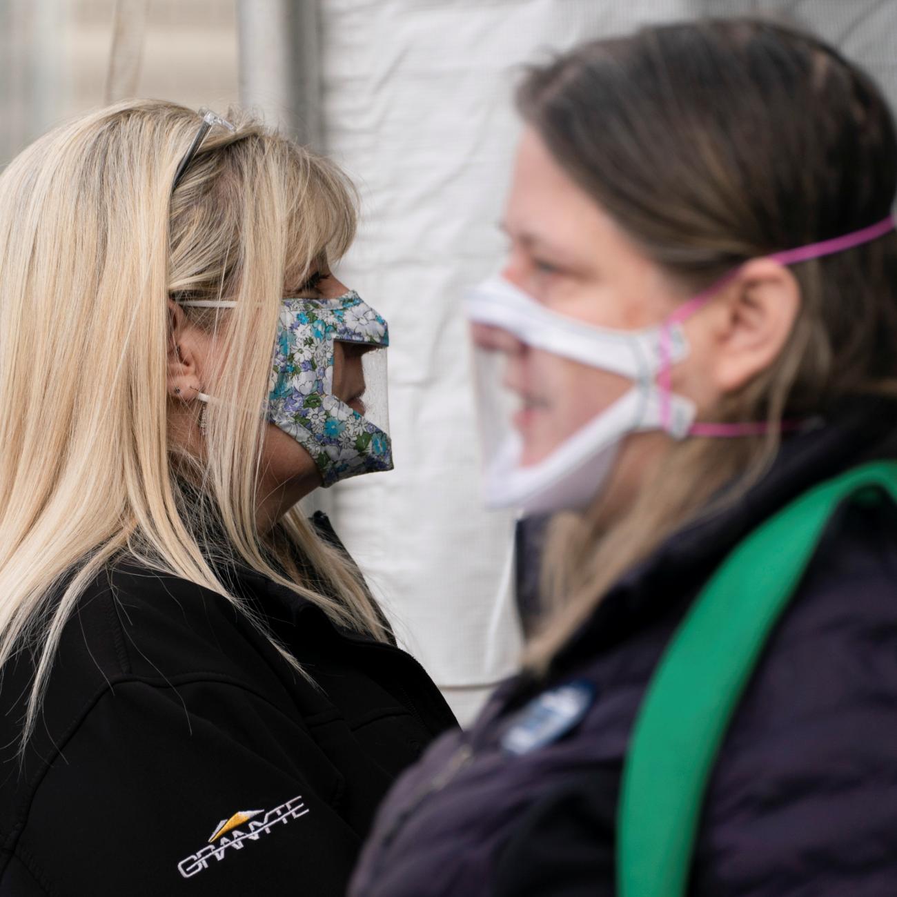 Interpreters wait at the entrance of a mobile coronavirus disease (COVID-19) vaccination clinic for members of the deaf and blind community, organized by the Swedish Medical Center in Seattle, Washington, U.S., March 19, 2021.