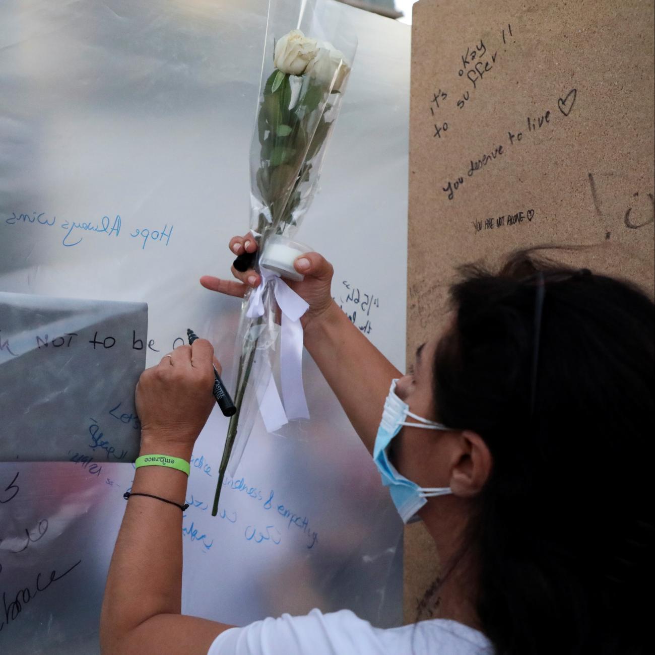 People write notes at the end point of a silent walk organized by Lebanese non-profit organization Embrace, marking World Suicide Prevention Day