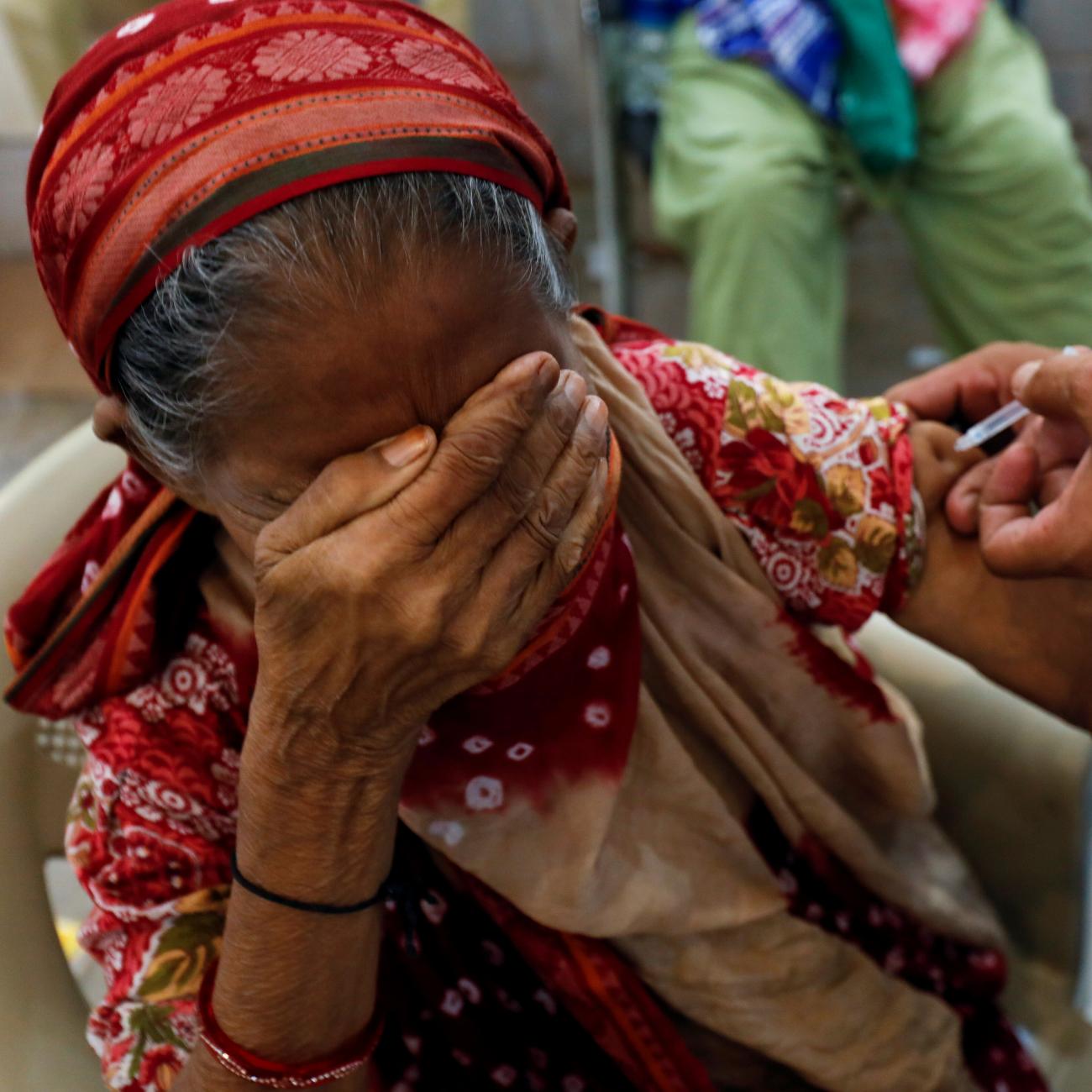 A woman, Basanti, 71, reacts as she receives a dose of the COVID-19 vaccine at a vaccination center in Karachi, Pakistan, on June 9, 2021.