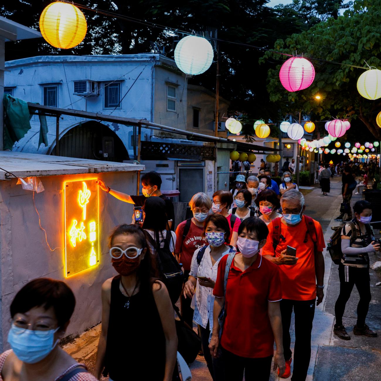 People walk near Chinese lanterns ahead of Mid-Autumn Festival at Tai O, in Hong Kong, China September 14, 2021.