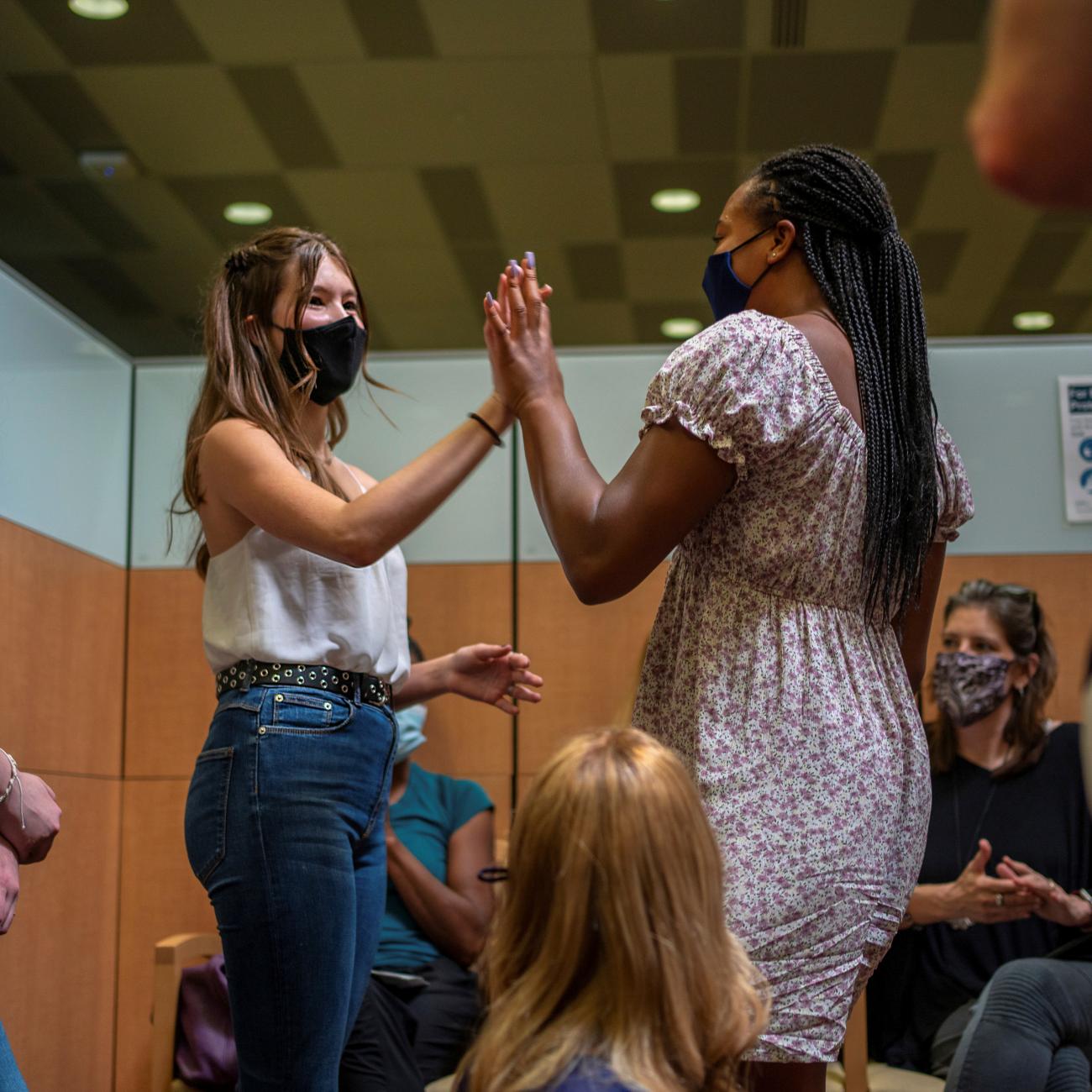 Ava Kreutziger, 14, gives Croix Hill, 15, a high five after Croix received her first dose of the COVID-19 vaccine at the Ochsner Center for Primary Care and Wellness, in New Orleans, Louisiana, May 13, 2021. 